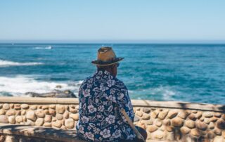 A senior sitting and making the most of retirement after their child learned how to get a power of attorney for a parent to help them manage the finances that were holding them back from making their golden years as fulfilling as possible!
