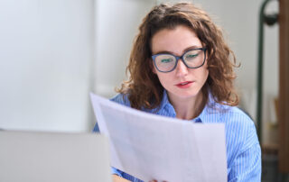 A specialist CPA in glasses with long, curly hair preparing an accurate and compliant California trust accounting for a trustee.