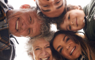 Several generations of a family coming together and smiling because their loved one learned what happens to a bank account when someone dies without a will in California and planned accordingly.