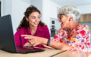 Senior woman and adult daughter reviewing trust and estate documents together at a table