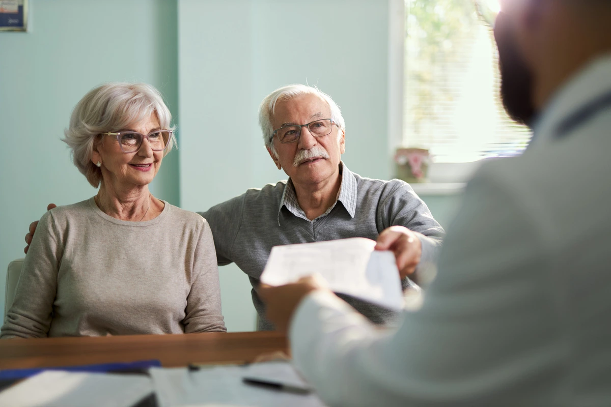 Elderly couple reviewing trust documents to protect assets from nursing home costs