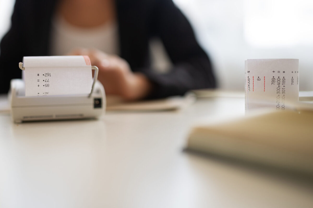 A trust accountant in a jacket and white shirt preparing an accurate trust accounting in California for a trustee.