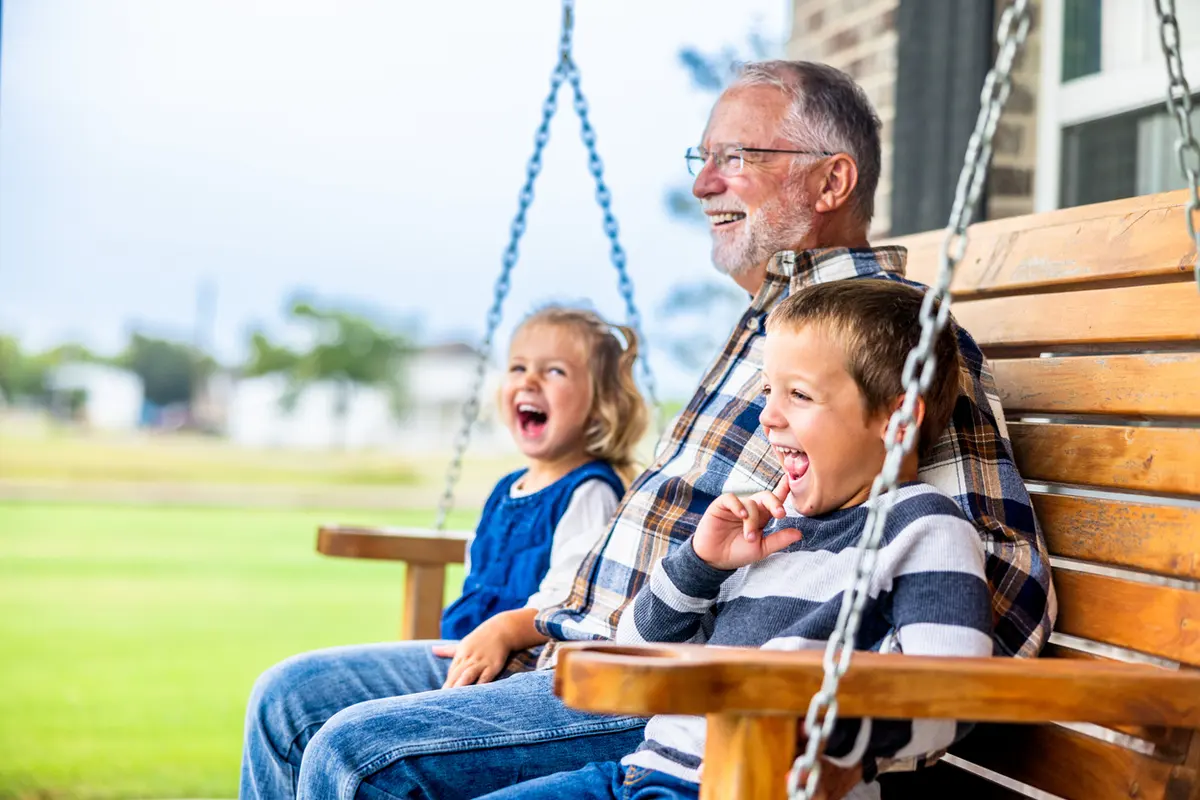what-is-included-in-an-estate-inventory Grandfather reading with a child on a porch swing, symbolizing legacy and estate planning