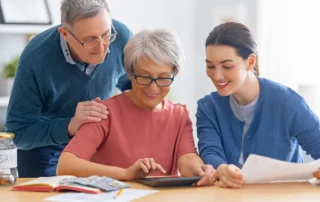 5 Signs You Need to Help Your Parents With Their Finances: daughter helps aging parents review bills