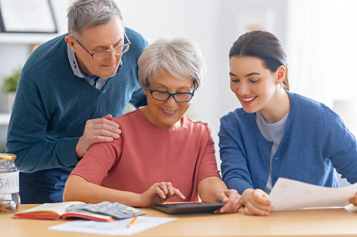 5 Signs You Need to Help Your Parents With Their Finances: daughter helps aging parents review bills
