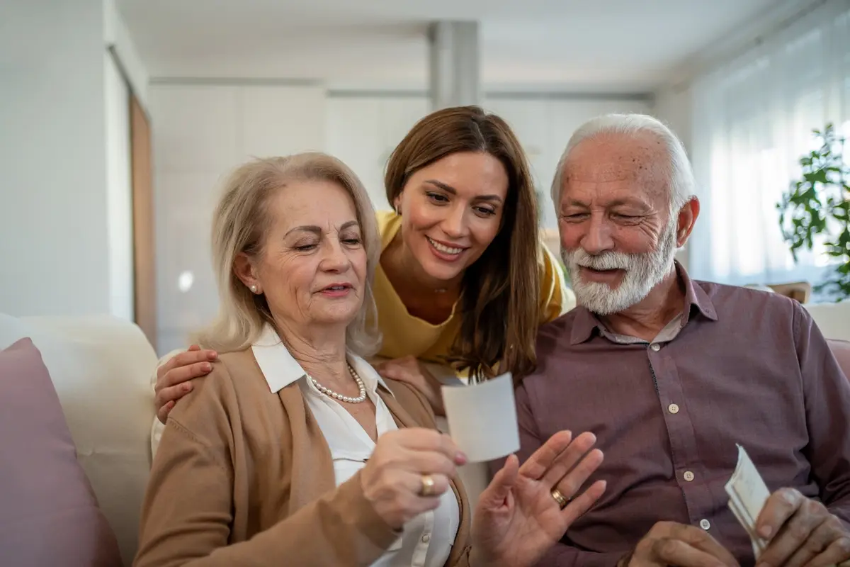 A hand over another offering some support, which is a fitting metaphor for the answer to the question, How do you talk to an aging parent about finances?
