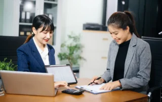 Two women review documents and tablet during a meeting about how long a court accounting takes