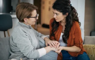Daughter and elder mother talking about how to get power of attorney for a parent inddors at home.