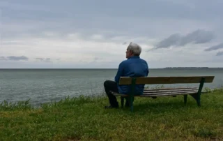 A senior sitting and making the most of retirement after their child learned how to get a power of attorney for a parent to help them manage the finances that were holding them back from making their golden years as fulfilling as possible!