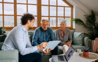 Advisor reviews financial with older couple, showing how to help your clients find the financial assistance