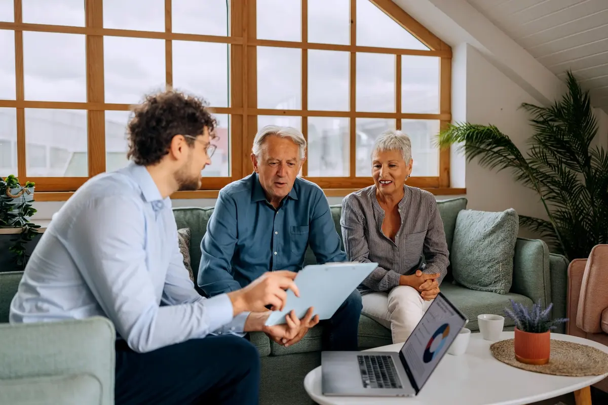 Advisor reviews financial with older couple, showing how to help your clients find the financial assistance