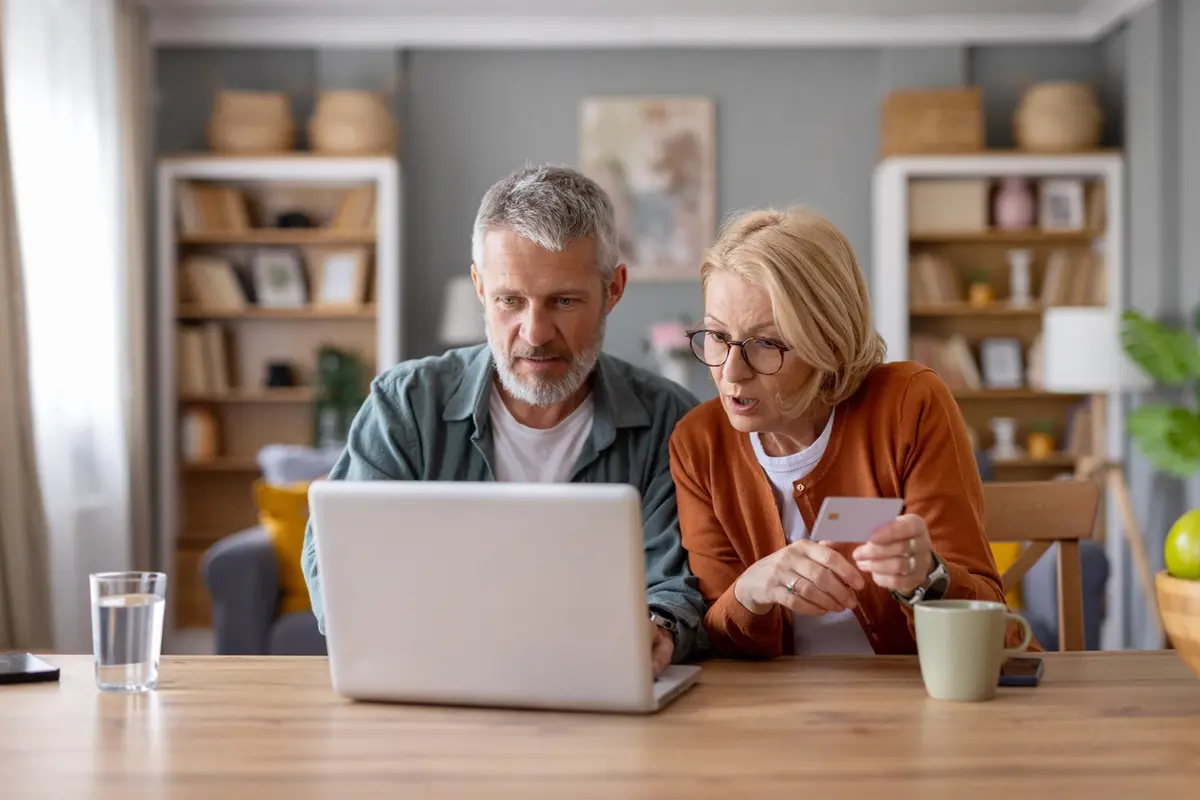 Older couple looks concerned at laptop, illustrating most popular senior scams in 2021