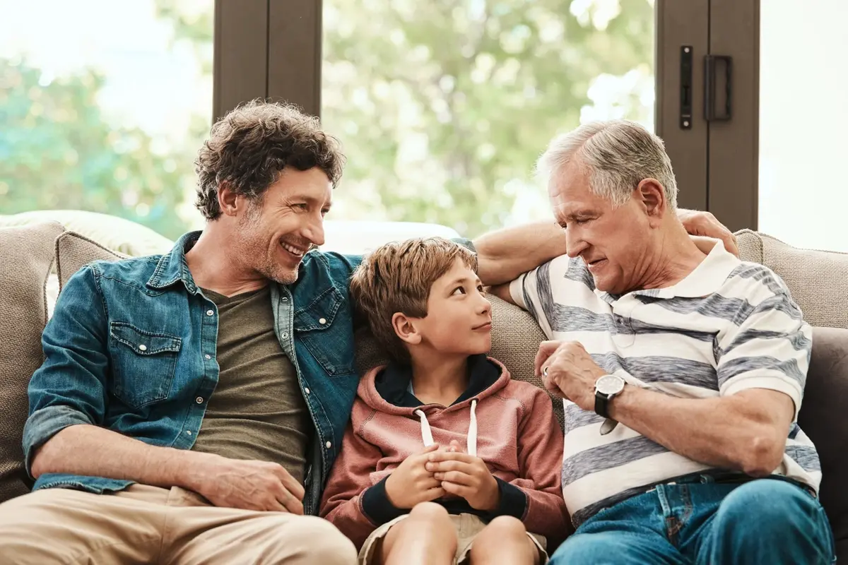 Three generations talk on a sofa, illustrating Testamentary Trust vs Living Trust differences