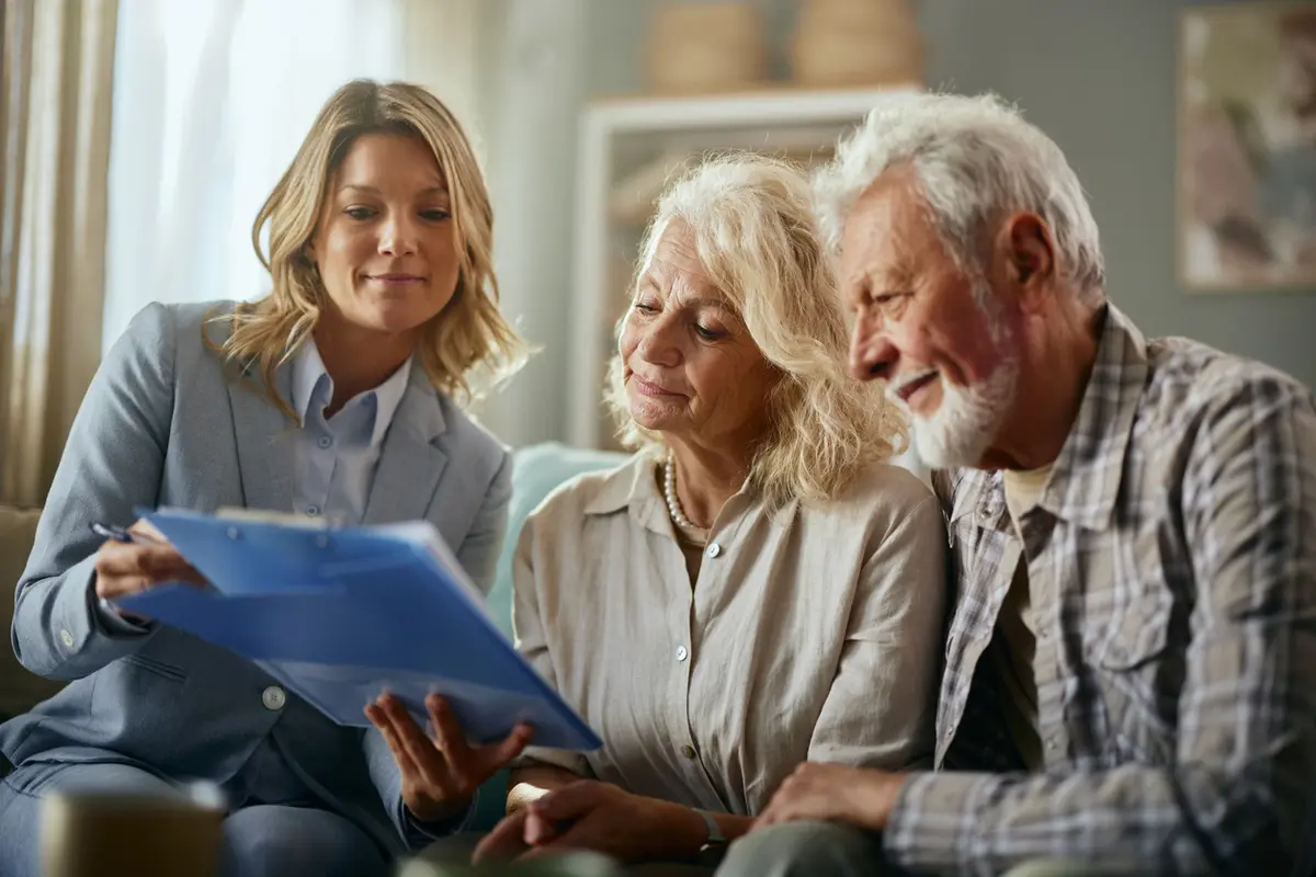 Advisor reviews papers with older couple, illustrating the benefits of creating a trust at home
