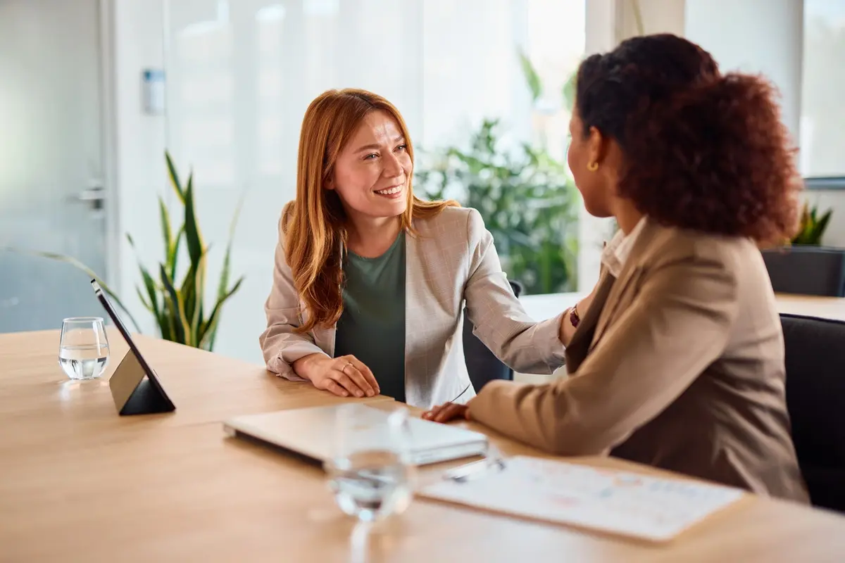 Trust Two women meet with a trustee advisor at an office table during a warm, supportive planning session.