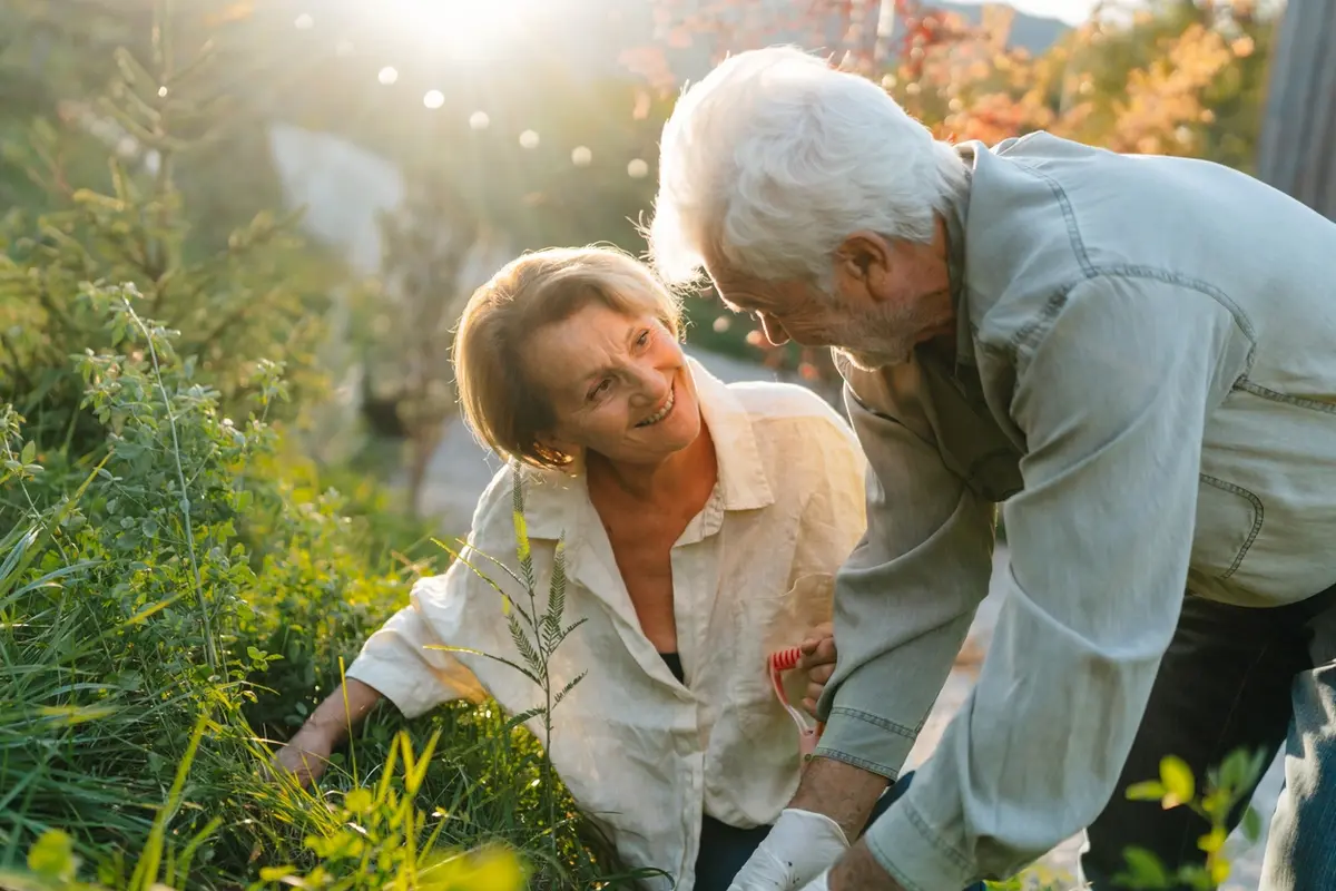Older man helps woman garden outdoors, illustrating a California Special Needs Trust