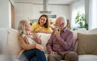 Signs your older parents might need financial help: adult child talks with senior parents at home