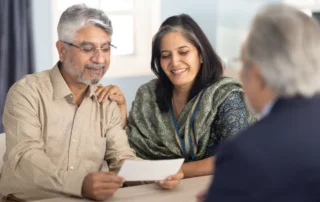 Couple reviewing financial documents with an advisor during a trust-focused financial consultation.